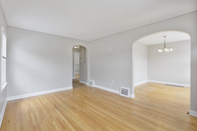 6000 S Mayfield Ave, Chicago, IL 60638 - spare room with arched walkways, light wood finished floors, and a chandelier