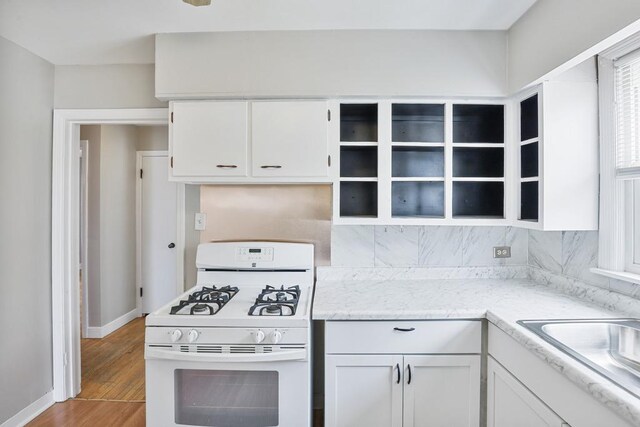 6000 S Mayfield Ave, Chicago, IL 60638 - kitchen with white gas range oven, white cabinets, open shelves, and tasteful backsplash