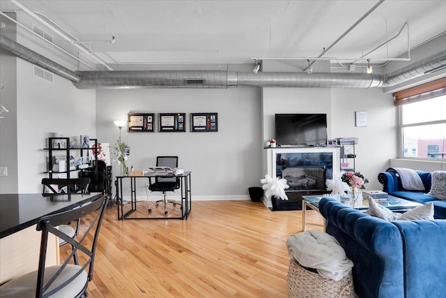 500 S Clinton St Unit 527, Chicago, IL 60607 - living area with light wood finished floors, an office area, a tile fireplace, and track lighting