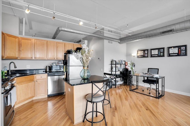 500 S Clinton St Unit 527, Chicago, IL 60607 - kitchen featuring stainless steel appliances, light wood-style floors, light brown cabinetry, and a center island
