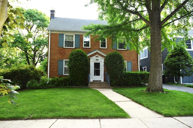 2008 Mcdaniel Ave, Evanston, IL 60201 - colonial-style house featuring brick siding, a front yard, and a chimney