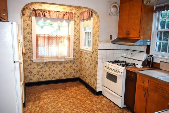 2008 Mcdaniel Ave, Evanston, IL 60201 - kitchen with white appliances, ventilation hood, light floors, arched walkways, and light countertops