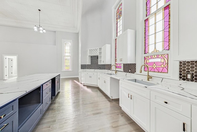 200 W Crawford St, Peotone, IL 60468 - kitchen with white cabinetry, backsplash, decorative light fixtures, light stone counters, and ornamental molding