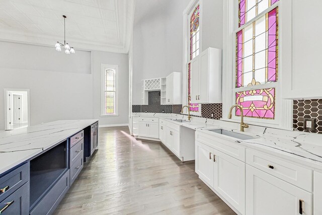 200 W Crawford St, Peotone, IL 60468 - kitchen with white cabinetry, backsplash, decorative light fixtures, light stone counters, and ornamental molding