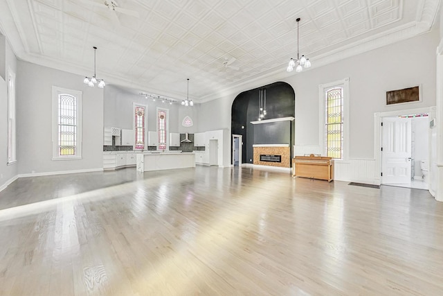 200 W Crawford St, Peotone, IL 60468 - unfurnished living room featuring arched walkways, a chandelier, light wood-style floors, and ornamental molding