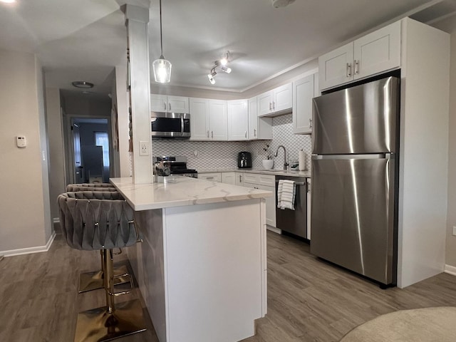 7125 Oconnell Dr Unit 102, Chicago Ridge, IL 60415 - kitchen featuring stainless steel appliances, a peninsula, white cabinetry, and wood finished floors