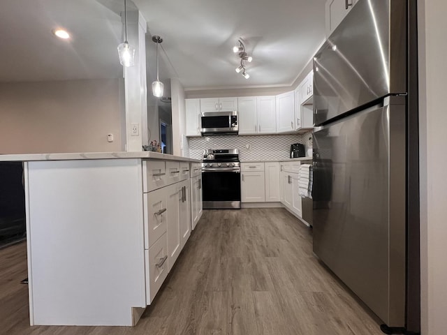 7125 Oconnell Dr Unit 102, Chicago Ridge, IL 60415 - kitchen with appliances with stainless steel finishes, tasteful backsplash, wood finished floors, white cabinetry, and pendant lighting