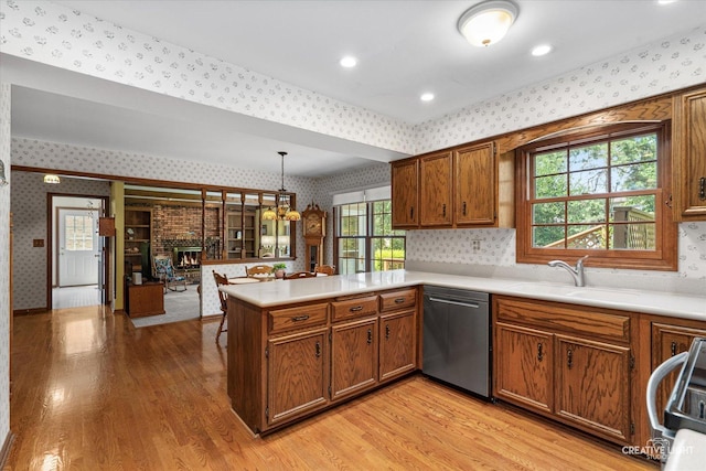 1453 Yale Ct, Naperville, IL 60565 - kitchen with wallpapered walls, stainless steel dishwasher, a peninsula, light wood-style floors, and brown cabinets