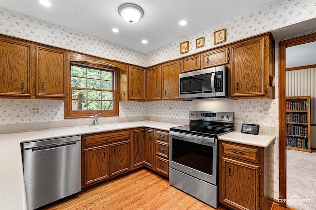 1453 Yale Ct, Naperville, IL 60565 - kitchen with appliances with stainless steel finishes, wallpapered walls, light countertops, brown cabinetry, and light wood-style floors