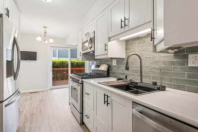 2733 Weeping Willow Dr Unit 26-C, Lisle, IL 60532 - kitchen featuring stainless steel appliances, tasteful backsplash, white cabinets, a chandelier, and light wood-style floors