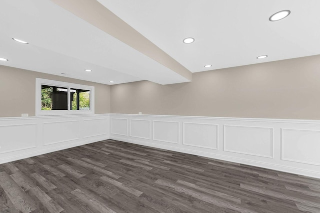 unfurnished room featuring a wainscoted wall, dark wood-type flooring, a decorative wall, and recessed lighting