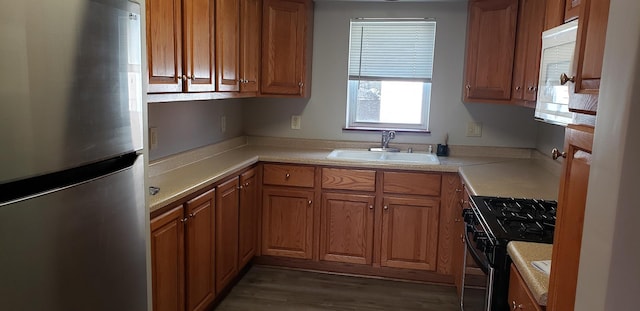 7155 W 71st St, Chicago, IL 60638 - kitchen featuring freestanding refrigerator, black range with gas stovetop, brown cabinetry, and light countertops