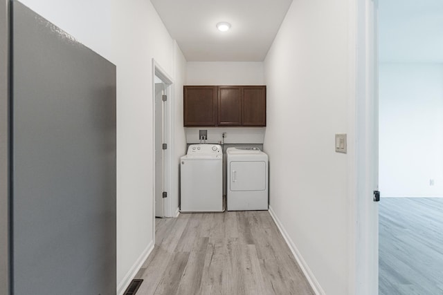402 N St, Monroe Center, IL 61052 - laundry area featuring washer and dryer, cabinet space, and light wood-style floors