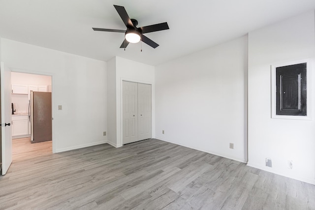 402 N St, Monroe Center, IL 61052 - unfurnished bedroom featuring freestanding refrigerator, light wood-style floors, a ceiling fan, and a closet