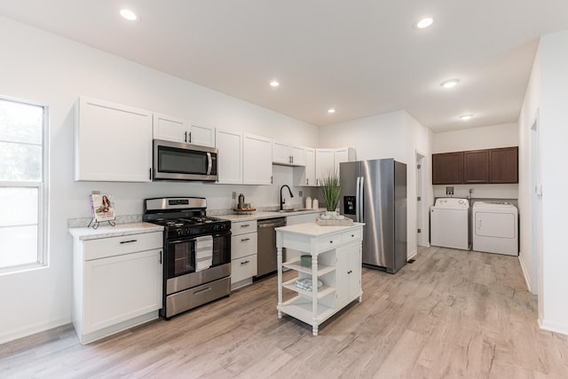 402 N St, Monroe Center, IL 61052 - kitchen featuring appliances with stainless steel finishes, washing machine and clothes dryer, light countertops, light wood finished floors, and recessed lighting