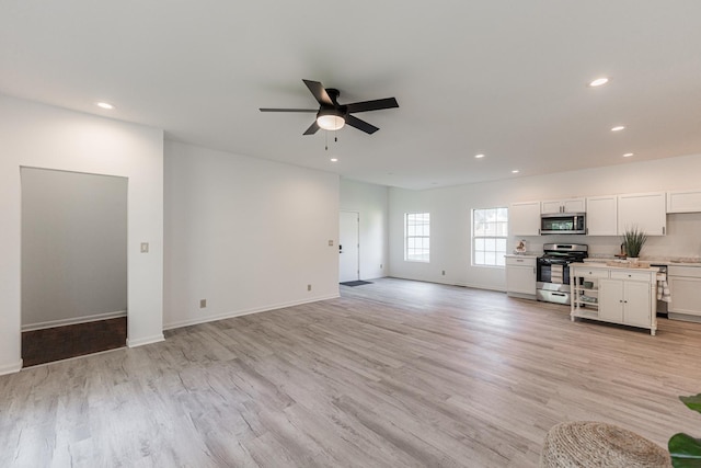 402 N St, Monroe Center, IL 61052 - unfurnished living room featuring a ceiling fan, light wood finished floors, and recessed lighting