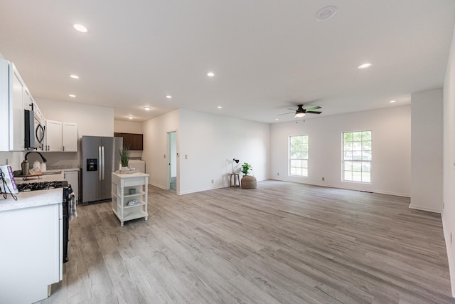 402 N St, Monroe Center, IL 61052 - kitchen featuring stainless steel fridge, ceiling fan, gas stove, light wood-style flooring, and light countertops