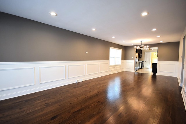 8812 S Euclid Ave, Chicago, IL 60617 - unfurnished living room featuring a chandelier, a wainscoted wall, recessed lighting, a decorative wall, and dark wood-style flooring