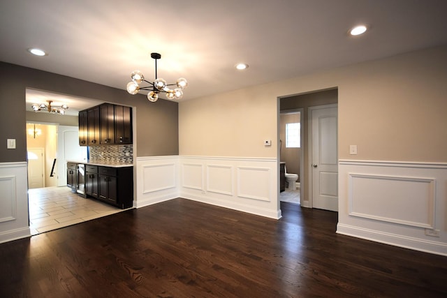 8812 S Euclid Ave, Chicago, IL 60617 - unfurnished dining area featuring a chandelier, wainscoting, dark wood finished floors, a decorative wall, and recessed lighting