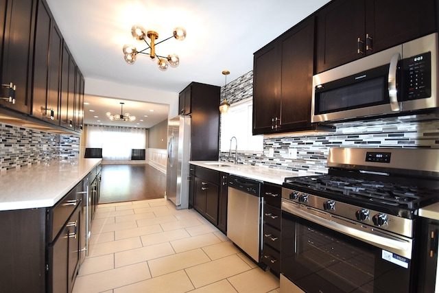 8812 S Euclid Ave, Chicago, IL 60617 - kitchen with appliances with stainless steel finishes, a chandelier, light countertops, tasteful backsplash, and wainscoting