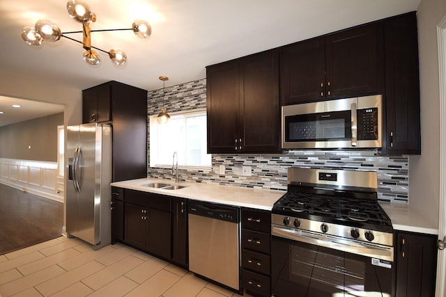 8812 S Euclid Ave, Chicago, IL 60617 - kitchen featuring stainless steel appliances, light countertops, backsplash, wainscoting, and dark brown cabinets
