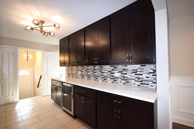 8812 S Euclid Ave, Chicago, IL 60617 - kitchen featuring beverage cooler, light countertops, a chandelier, backsplash, and a wainscoted wall