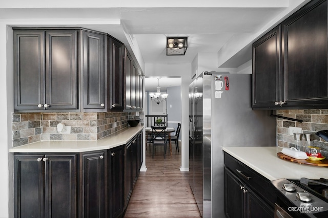 1258 Chalet Rd Unit 104, Naperville, IL 60563 - kitchen with light countertops, wood finished floors, decorative backsplash, a chandelier, and stainless steel stove