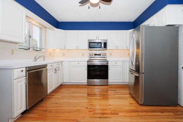 2214 E Lincoln St Unit 14, Bloomington, IL 61701 - kitchen featuring appliances with stainless steel finishes, ceiling fan, white cabinetry, light wood finished floors, and light countertops