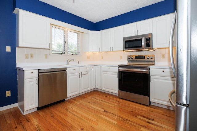 2214 E Lincoln St Unit 14, Bloomington, IL 61701 - kitchen featuring stainless steel appliances, decorative backsplash, light wood-type flooring, and light countertops