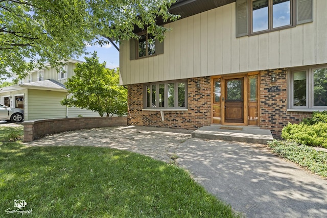 509 Apollo Dr, Joliet, IL 60435 - view of exterior entry with brick siding, a yard, and a patio area