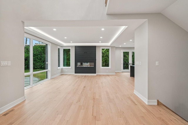 2700 Fontana Dr, Glenview, IL 60025 - unfurnished living room with plenty of natural light, light wood finished floors, a tray ceiling, recessed lighting, and a multi sided fireplace