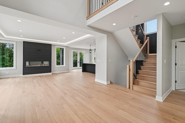 2700 Fontana Dr, Glenview, IL 60025 - unfurnished living room featuring light wood-style floors, stairs, a raised ceiling, and recessed lighting