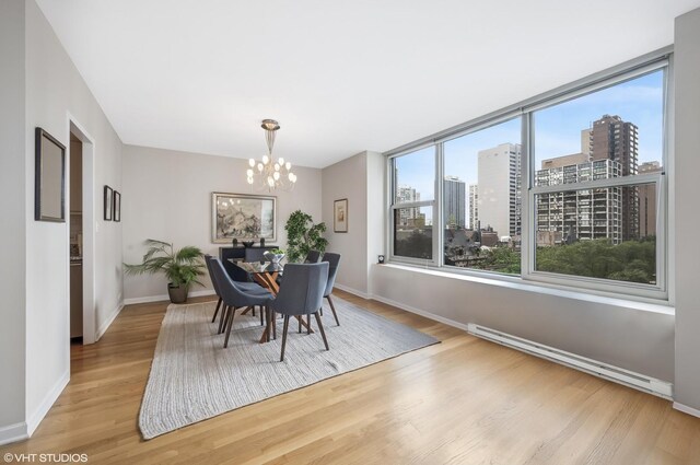 1325 N State Pkwy Unit 7A, Chicago, IL 60610 - dining space with baseboard heating, wood finished floors, a chandelier, and a city view