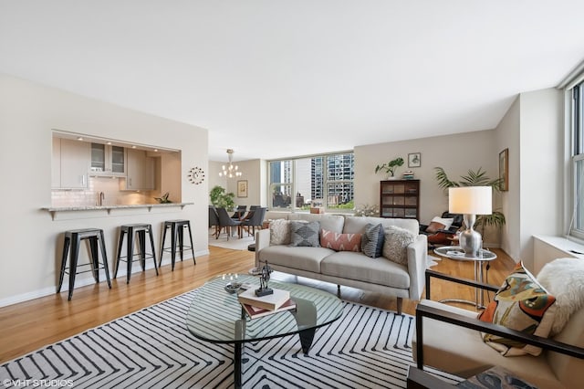 1325 N State Pkwy Unit 7A, Chicago, IL 60610 - living room featuring light wood-style floors, a chandelier, and a wall of windows