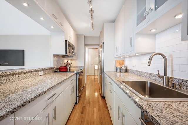 1325 N State Pkwy Unit 7A, Chicago, IL 60610 - kitchen with appliances with stainless steel finishes, light wood finished floors, white cabinetry, tasteful backsplash, and glass insert cabinets