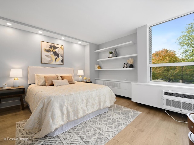 1455 N Sandburg Ter Unit 209B, Chicago, IL 60610 - bedroom featuring wood finished floors, multiple windows, radiator heating unit, a wall mounted AC, and recessed lighting