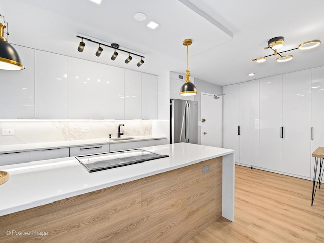 1455 N Sandburg Ter Unit 209B, Chicago, IL 60610 - kitchen featuring freestanding refrigerator, modern cabinets, black electric stovetop, and white cabinetry