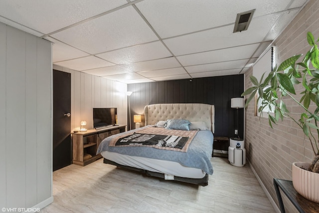 303 W 8th Pl, Hobart, IN 46342 - bedroom with a paneled ceiling, brick wall, and wood walls