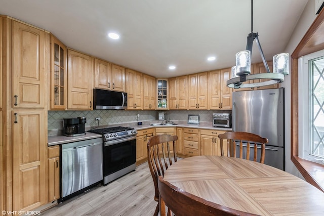 303 W 8th Pl, Hobart, IN 46342 - kitchen with appliances with stainless steel finishes, light wood-style flooring, backsplash, light countertops, and recessed lighting