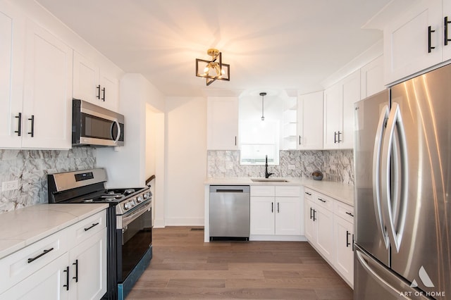 9156 S Sawyer Ave, Evergreen Park, IL 60805 - kitchen with appliances with stainless steel finishes, light wood-style flooring, decorative backsplash, and white cabinetry