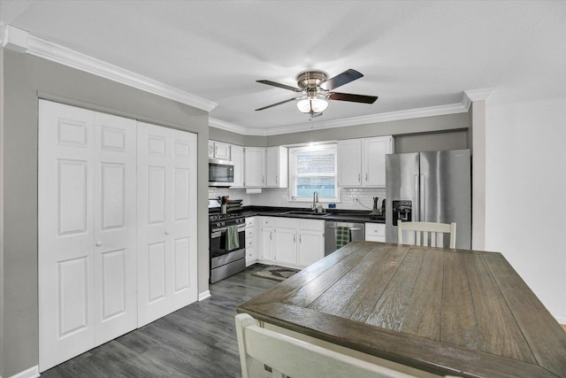 1901 Sumac Dr, Champaign, IL 61821 - kitchen featuring stainless steel appliances, a ceiling fan, dark countertops, white cabinetry, and dark wood finished floors