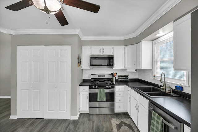1901 Sumac Dr, Champaign, IL 61821 - kitchen featuring appliances with stainless steel finishes, dark countertops, dark wood-style flooring, ceiling fan, and ornamental molding