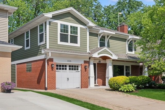 806 S Walnut Ave, Arlington Heights, IL 60005 - view of front facade featuring a garage, brick siding, a chimney, and driveway