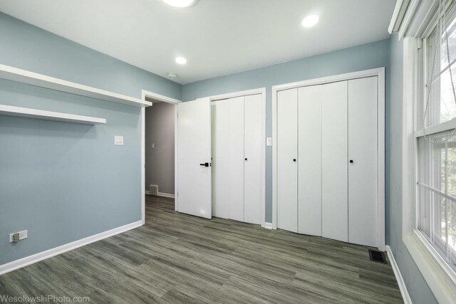 651 Clearmont Dr, Elk Grove Village, IL 60007 - unfurnished bedroom with multiple closets, wood finished floors, and recessed lighting