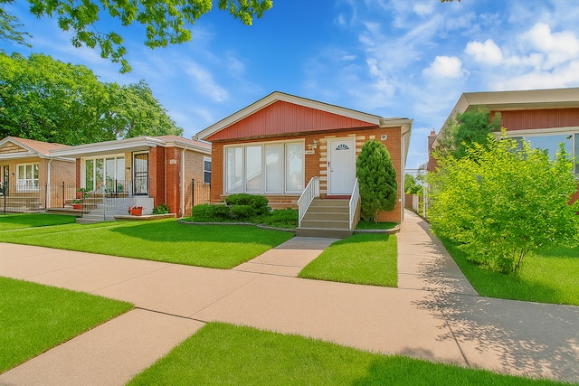9007 S Cregier Ave, Chicago, IL 60617 - view of front facade featuring brick siding and a front lawn