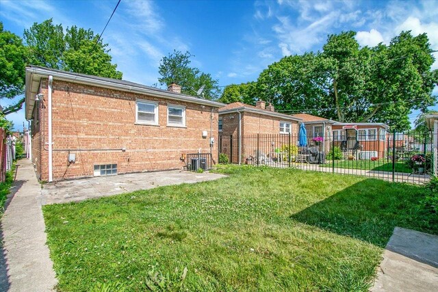 9007 S Cregier Ave, Chicago, IL 60617 - rear view of house with a patio area, brick siding, and a chimney
