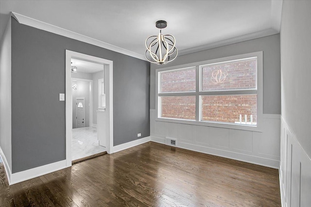 9007 S Cregier Ave, Chicago, IL 60617 - spare room featuring a chandelier, a wainscoted wall, wood finished floors, and crown molding