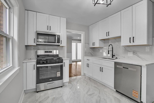 9007 S Cregier Ave, Chicago, IL 60617 - kitchen with stainless steel appliances, tasteful backsplash, white cabinetry, and light marble finish floors