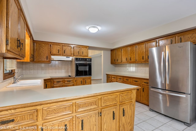 13938 S Trails End Dr, Homer Glen, IL 60491 - kitchen featuring freestanding refrigerator, black oven, under cabinet range hood, a peninsula, and light countertops