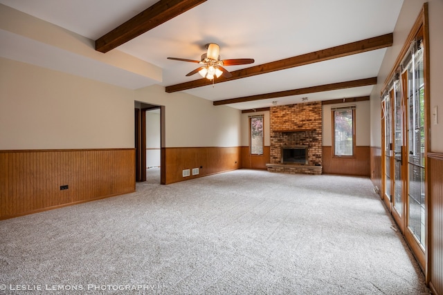 13938 S Trails End Dr, Homer Glen, IL 60491 - unfurnished living room with a wainscoted wall, beam ceiling, ceiling fan, wooden walls, and a brick fireplace